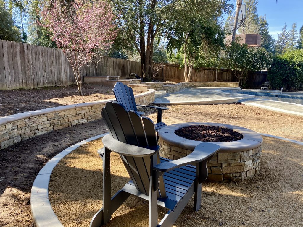 Custom fire pit gathering area constructed as part of the expanded Wedemeyer backyard renovation, creating a welcoming outdoor living space for family and friends.