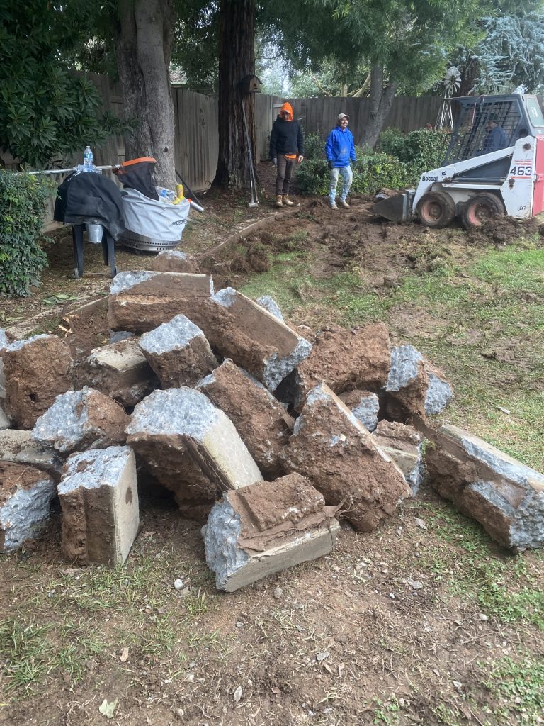Demolition and excavation begin at the Wedemeyer backyard as existing concrete is removed and grading begins for the new outdoor living environment.