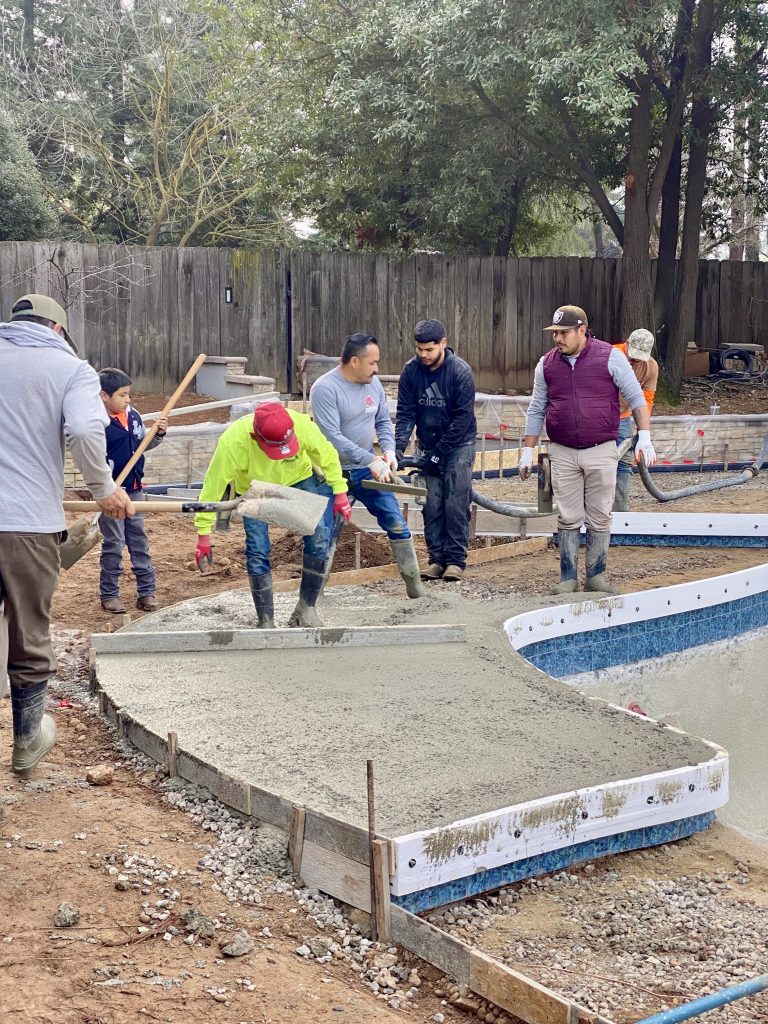 Concrete pump placing the new pool deck as the Sunset Construction crew orchestrates the concrete in carefully planned sections during the Wedemeyer backyard renovation.